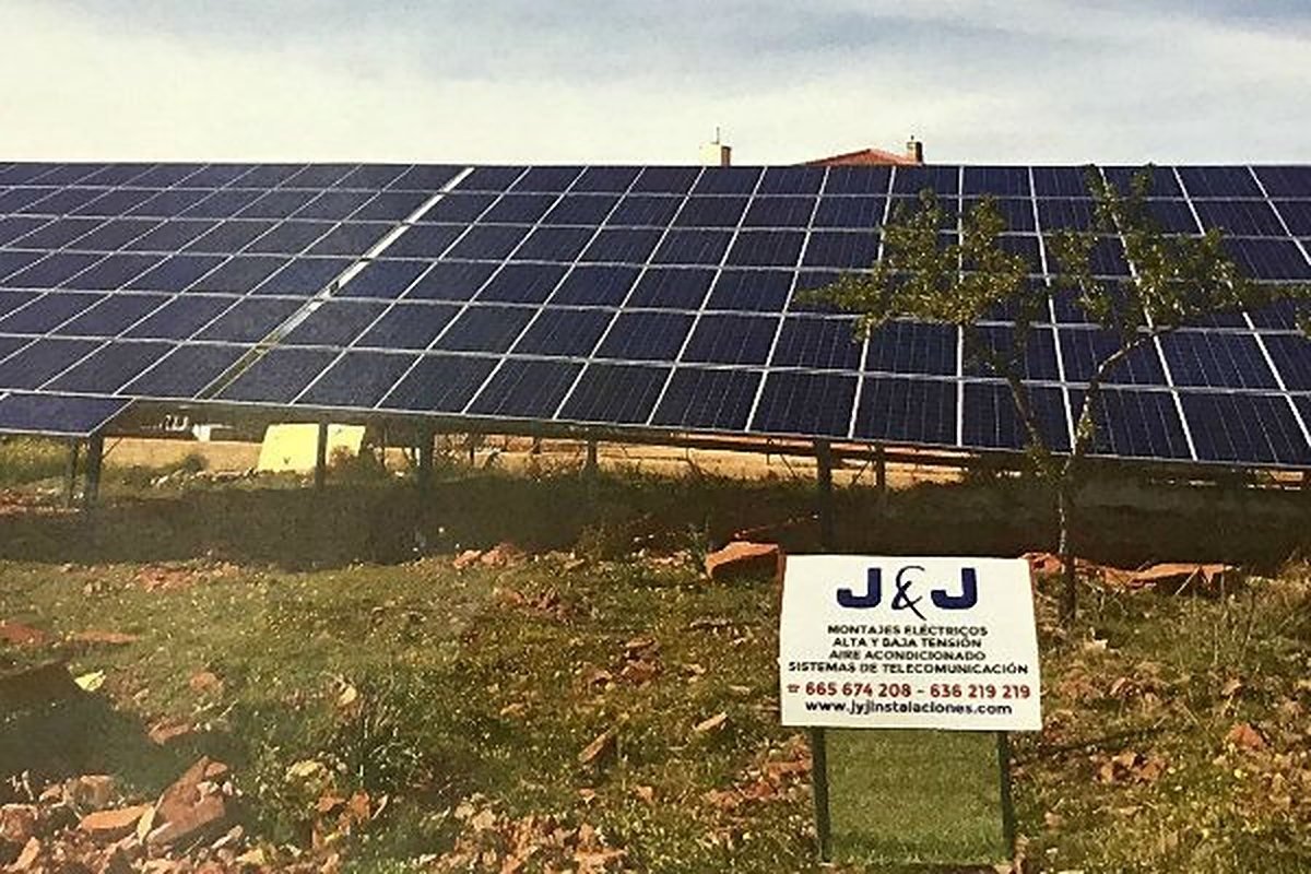 Planta solar en terreno con el cartel de J&J Electroclima